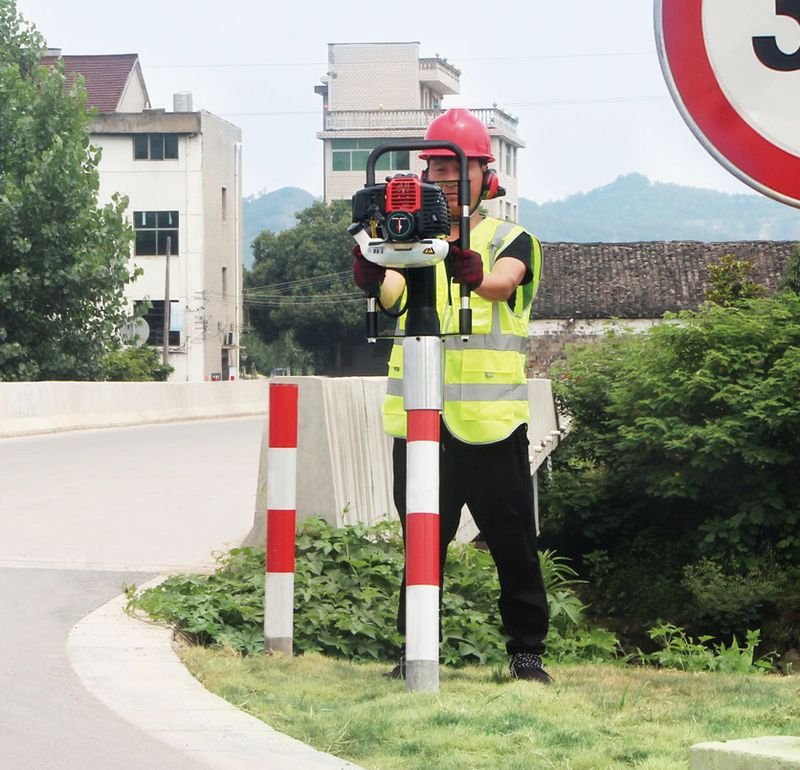 Landscaping & signage – petrol post driver at work