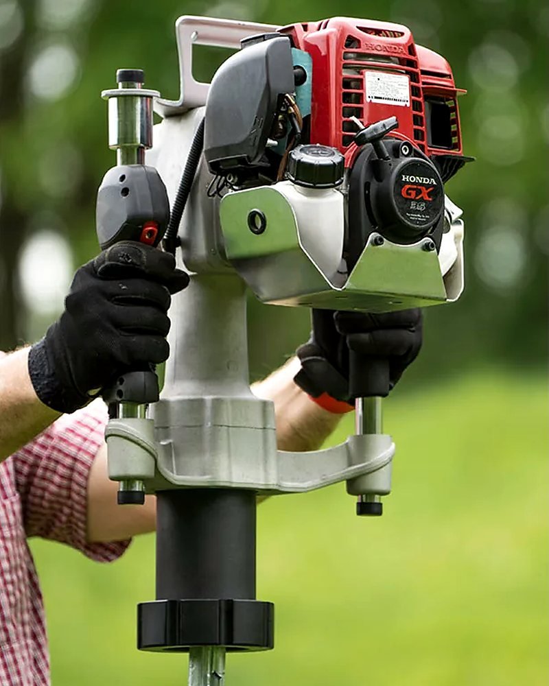 Close-up of a petrol post driver driving a steel fence post